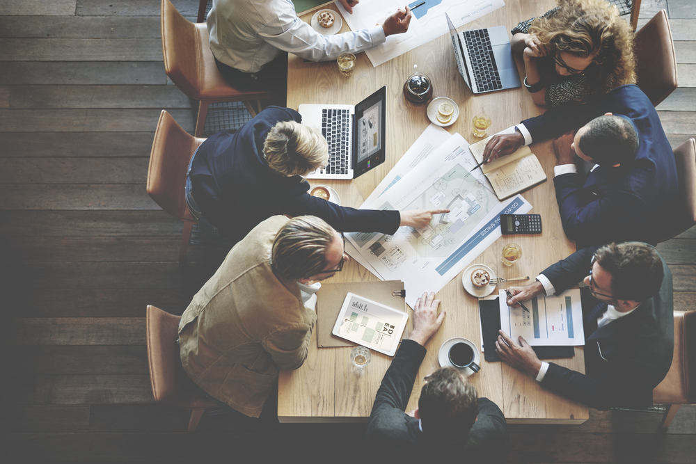 a-group-of-people-sitting-around-a-wooden-table