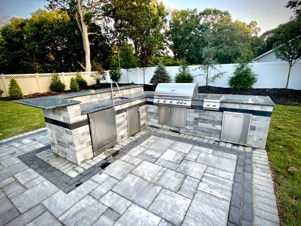 an-outdoor-kitchen-with-a-grill-and-sink